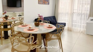 Een moderne eethoek met een ronde tafel, beige stoelen en roze placemats.