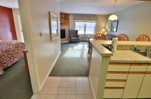 A compact living space with a kitchen, dining area, and a bedroom.