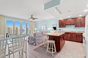 Relax in a spacious room with a balcony offering a city view, a cozy seating area, and a small kitchen.