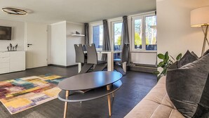 A modern living room with a sofa, a dining table, and a kitchen area. - 1 bedroom gorgeous home in Stralsund (Stralsund)