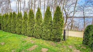 A neatly trimmed hedge in a landscaped area with a metal fence and a paved path. - 1 bedroom gorgeous home in Stralsund (Stralsund)