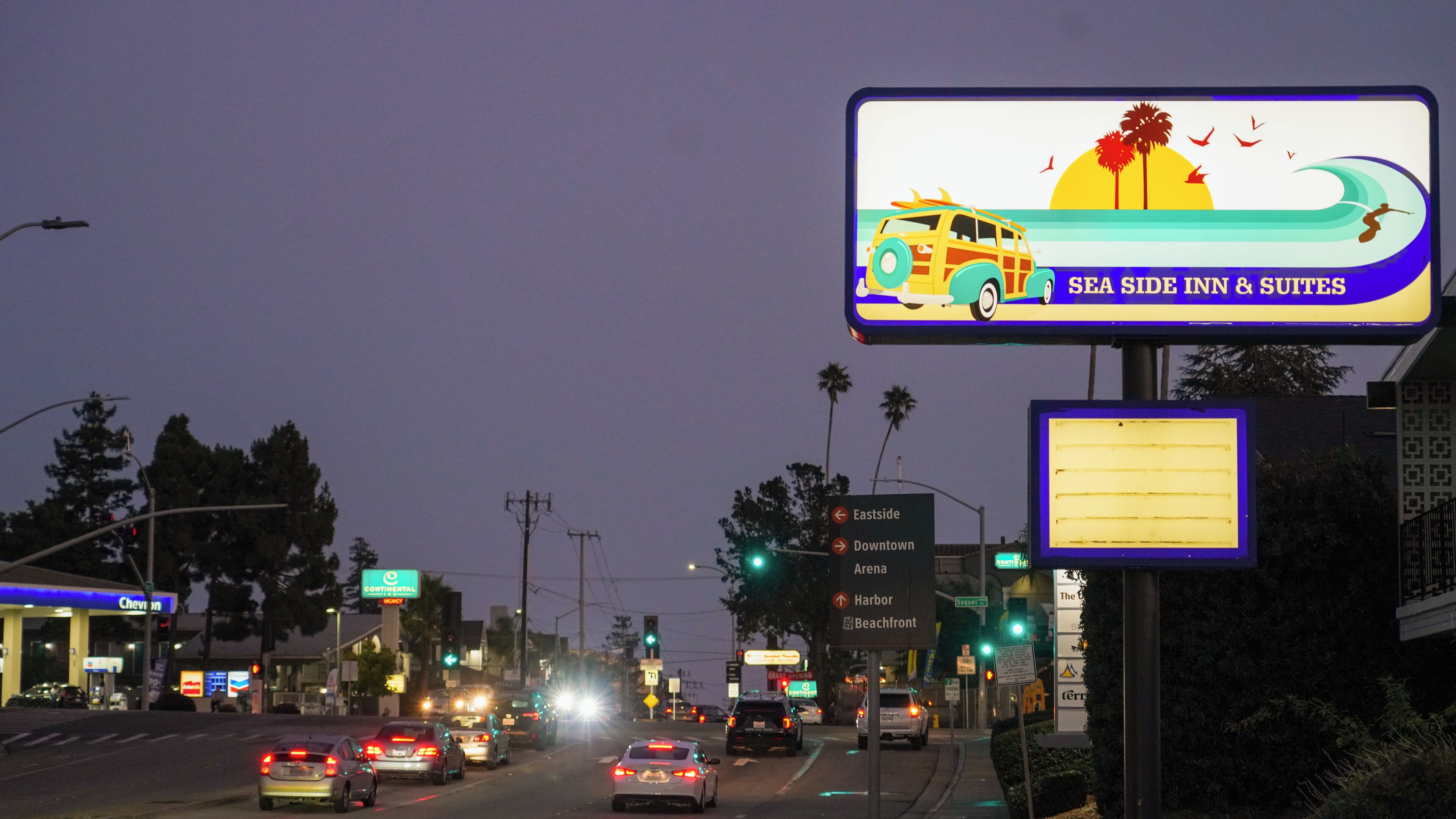 A busy street with a billboard advertising a hotel.