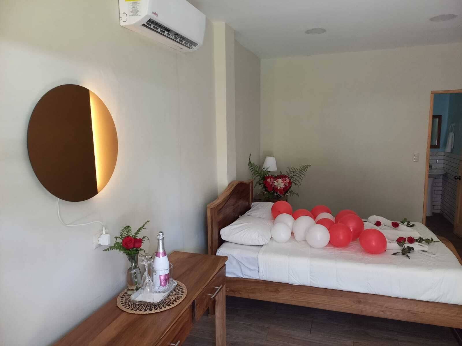 A bedroom with a bed, bedside table, and a wall-mounted air conditioner.