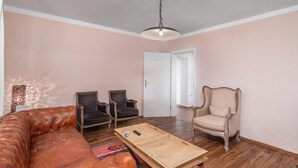 A living room with a brown leather sofa, two dark armchairs, a wooden coffee table, and a vintage armchair. - Beach front home in Rab (Rab)