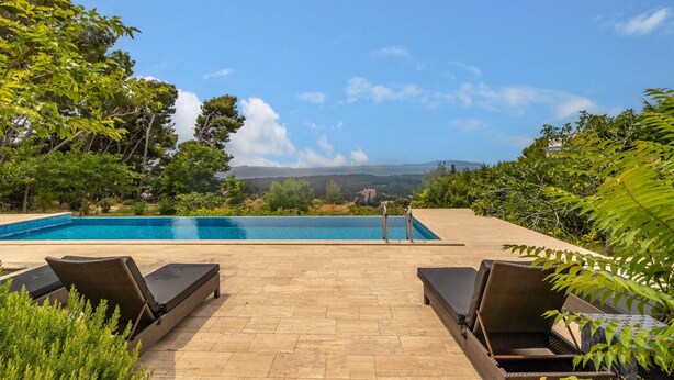 A poolside area with two lounge chairs and a clear view of the landscape. - Beach front home in Rab (Rab)