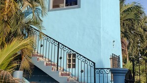 A blue building with a staircase and a window.