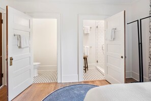 Bathroom features a toilet, shower area, and towel rack.