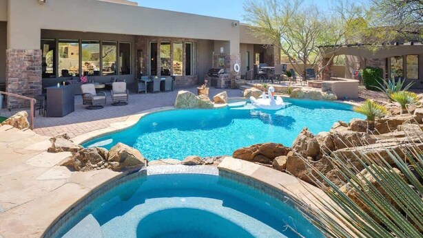 Una piscina con hidromasaje, mobiliario de exterior y una zona de terraza.