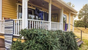 A house with a porch, a small garden, and clothes hanging on a line.