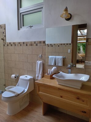 Un baño con inodoro, lavamanos y espejo.