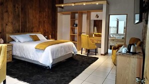 A bedroom with a bed, a desk, a chair, and a wardrobe. - Asgard Resort (Santiago Sacatepéquez)