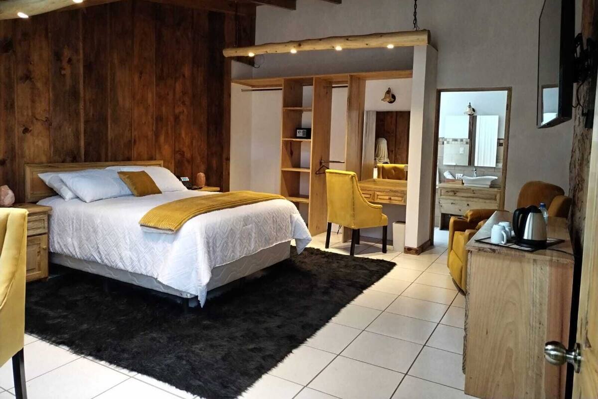 A bedroom with a bed, a desk, a chair, and a wardrobe.