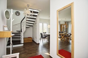 En modern inredning med en trappa, ett matområde och en stor spegel.