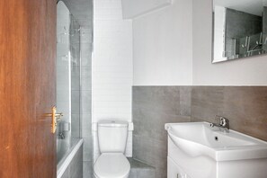 A bathroom with a shower, toilet, and sink.