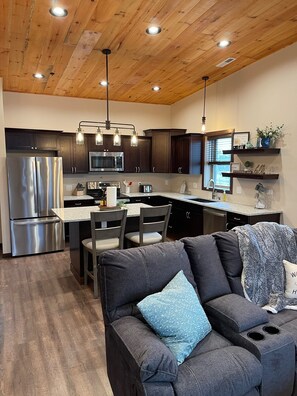 A modern kitchen with wooden ceiling, stainless steel appliances, and pendant lighting. - Beautiful Apartment Located Downtown Dells! (Wisconsin Dells)