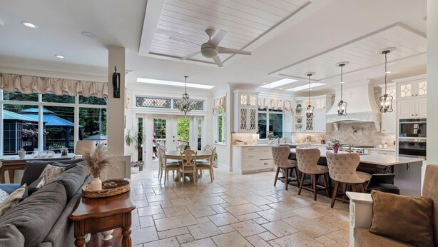A spacious kitchen with white cabinetry, a central island, and pendant lighting.