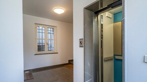 A hallway with a window, an elevator, and a door. - GuestHost - Mercatovecchio Ivy House (Udine)