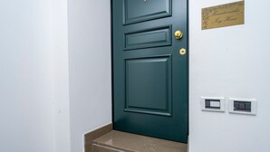A dark green door with a brass doorknob and a brass plate above it. - GuestHost - Mercatovecchio Ivy House (Udine)