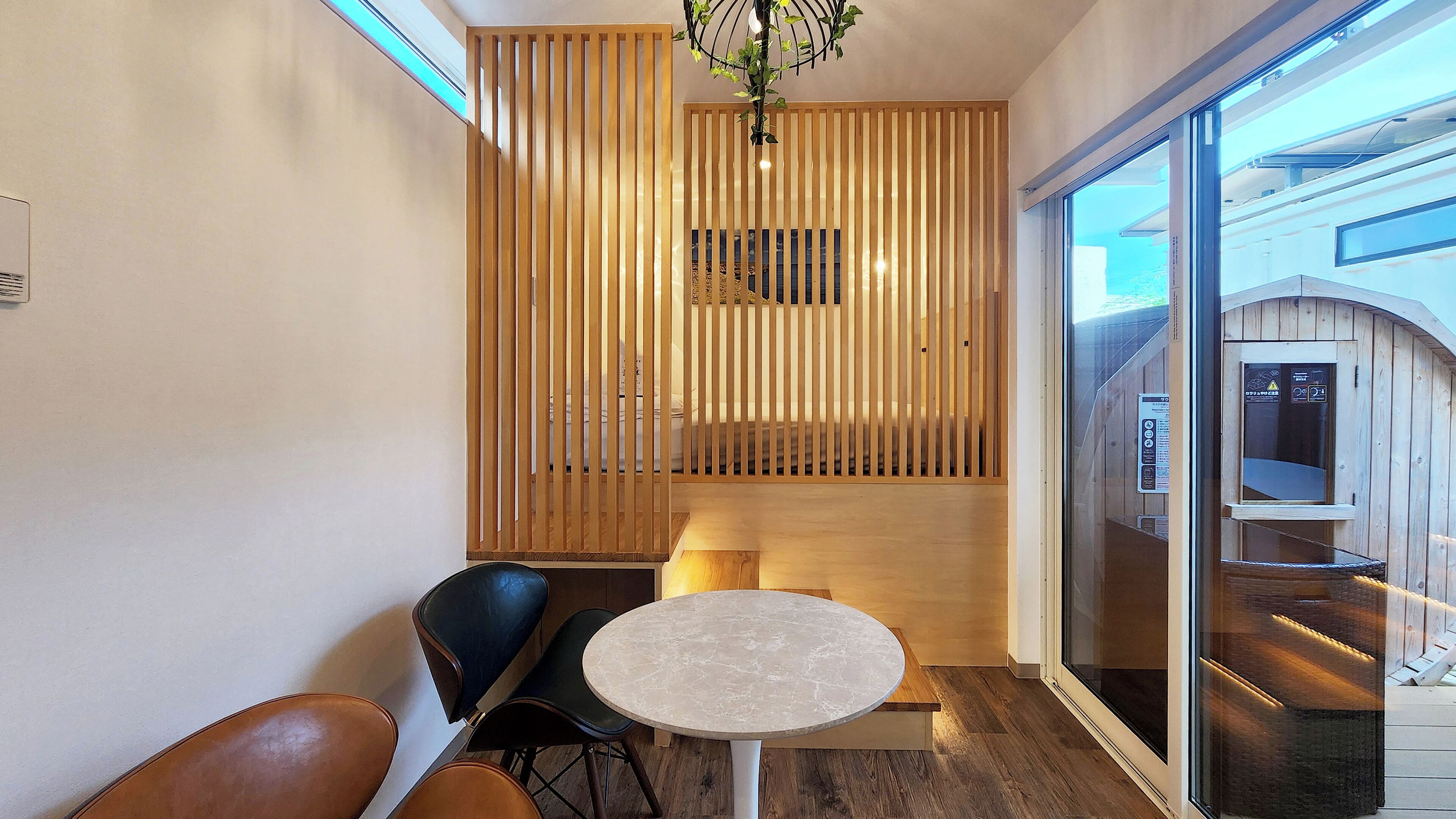 A modern interior with a wooden partition, a round table, and two chairs.
