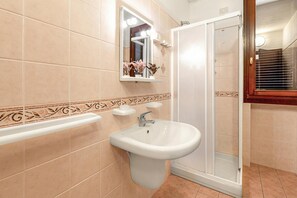A bathroom with a sink, mirror, and shower. - Porto Letizia Mozart 4, Porlezza, Italy (Porlezza)
