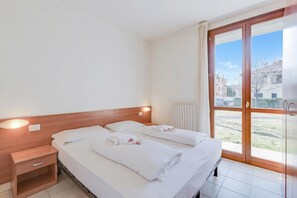 A hotel room with a bed, bedside table, and a view through a glass door. - Porto Letizia Verdi 1, Porlezza, Italy (Porlezza)
