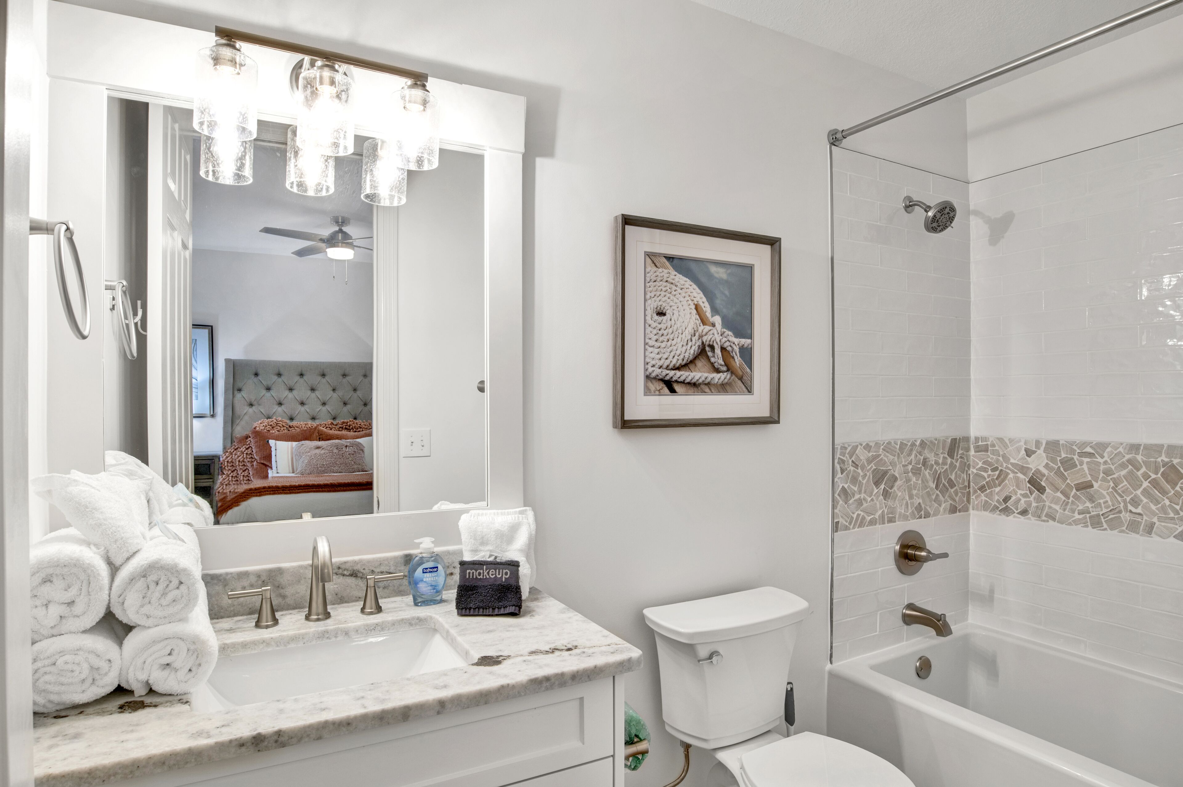 A bathroom with a marble sink, a toilet, a bathtub, and a shower.