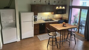 A compact kitchen with a central island, built-in appliances, and a view to the outside. - Charming 1 Bedroom Industrial Loft w/ Dedicated Parking (Portland)