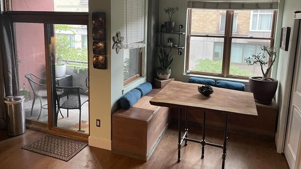 A cozy kitchen with a wooden table, built-in bench seating, and potted plants. - Charming 1 Bedroom Industrial Loft w/ Dedicated Parking (Portland)