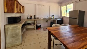 A compact kitchen with a wooden table, a refrigerator, and basic appliances. - Una escapada de vacaciones espaciosa y privada en Marbella. (¡Admite mascotas!)  (Marbella)