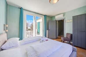 Una camera d'albergo con un letto, una sedia, un armadio e vista sull'esterno.