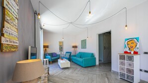 A modern living room with a herringbone floor, teal sofas, and a white cabinet with decorative tiles. - Porto Letizia Primula 1, Porlezza, Italy (Porlezza)