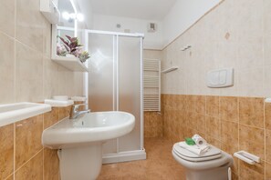 Une salle de bain avec un lavabo, des toilettes et une douche.