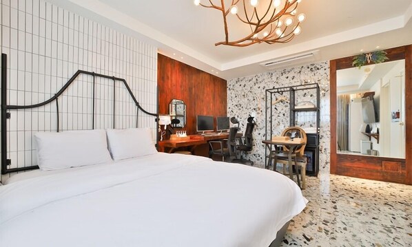 A modern hotel room with a large bed, a desk with computers, a chair, and a unique chandelier. - Hotel February Tongyeong Jukrim (Tongyeong)