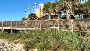A beachside view with a wooden boardwalk, a Ferris wheel, and a hotel with balconies. - One Bedroom Condo, Myrtle Beach 3317100 (Myrtle Beach)