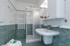 A bathroom with a shower, a sink, and a toilet.