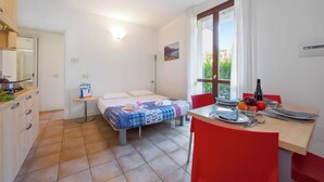 A bedroom with a bed, bedside table, and a window with curtains. - Porto Letizia Venezia 3, Porlezza, Italy (Porlezza)