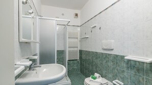 A bathroom with a sink, toilet, and shower. - Porto Letizia Leoncavallo 2, Porlezza, Italy (Porlezza)