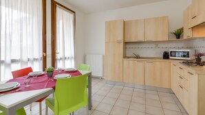 Een moderne keuken met houten kastjes, een magnetron en een gasfornuis.