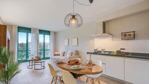 A modern kitchen with a dining area, large windows, and a view of greenery. - Porto Letizia P18, Porlezza, Italy (Porlezza)