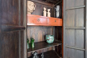 Un meuble en bois doté d’une étagère où sont disposés des objets décoratifs.