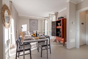 A dining area with a table set for four, chairs, a decorative mirror, and a cabinet with decorative items. - Porto Letizia Viola 5, Porlezza, Italy (Porlezza)