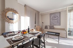 A modern dining area with a round mirror, a dining table set with plates, glasses, and a fruit bowl. - Porto Letizia Viola 5, Porlezza, Italy (Porlezza)
