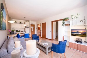 A modern living room with a sofa, chairs, a coffee table, and a TV. - Porto Letizia S3 B1, Porlezza, Italy (Porlezza)
