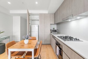A modern kitchen with a central island, a built-in oven, and a microwave.