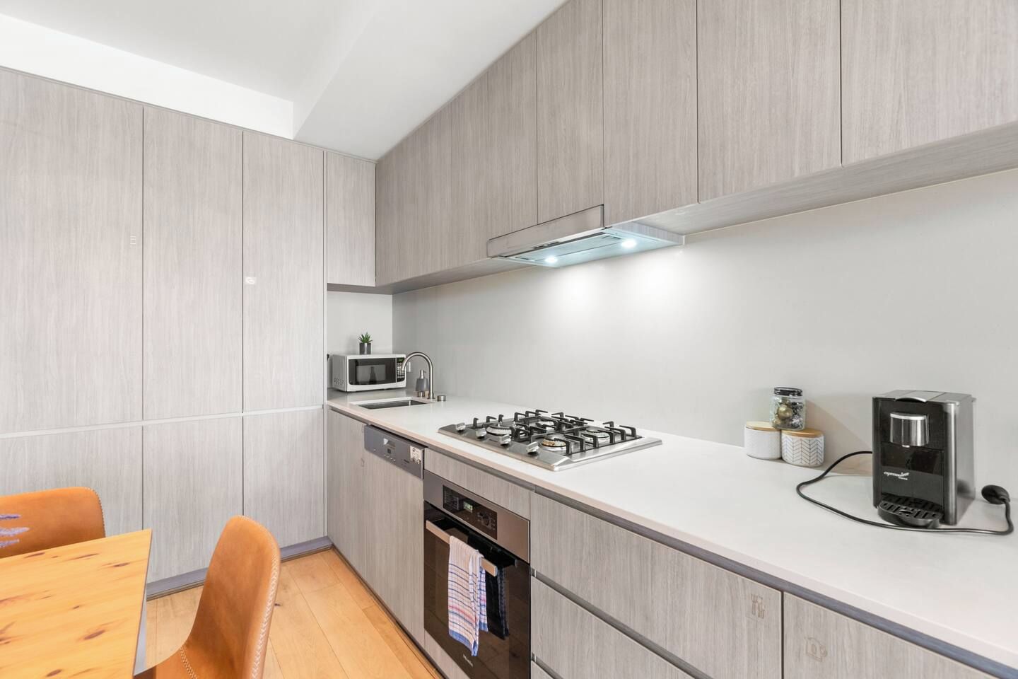 A modern kitchen with a gas stove, microwave, and coffee maker.