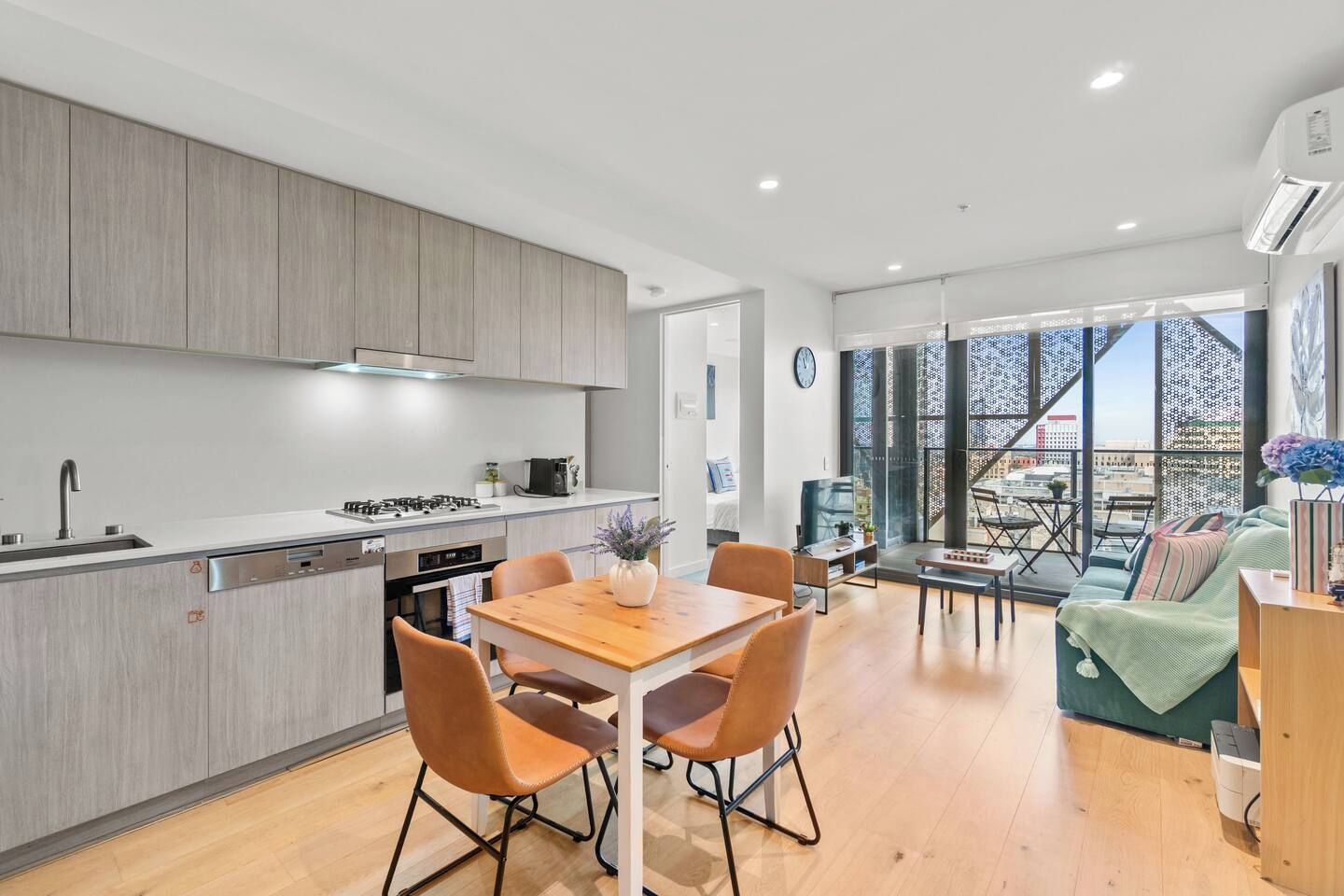 Una cocina moderna con comedor, un sofá y vistas a la ciudad.