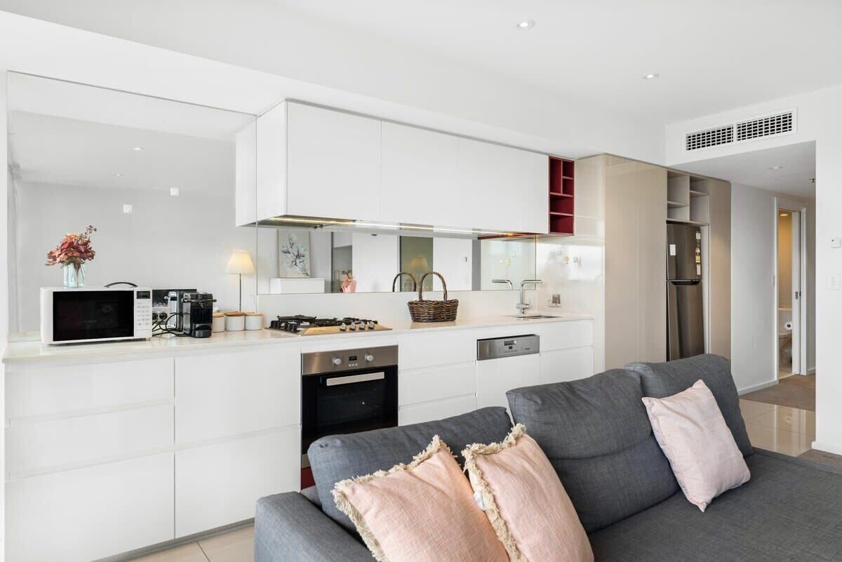 A modern kitchen with white cabinetry, a built-in microwave, and a gas stove.