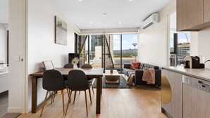 A modern apartment with a dining area, kitchen, and living space. - The 2BR City Escape - Stylish and Mordern (Adelaide)