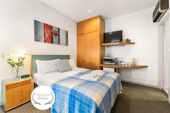 Tabla de planchar con plancha y ropa de cama 