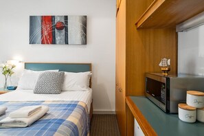 Tabla de planchar con plancha y ropa de cama 